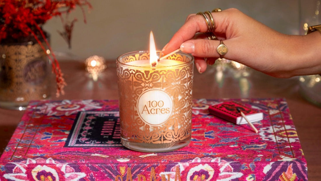 Golden Winter three-wick candle surrounded by botanicals